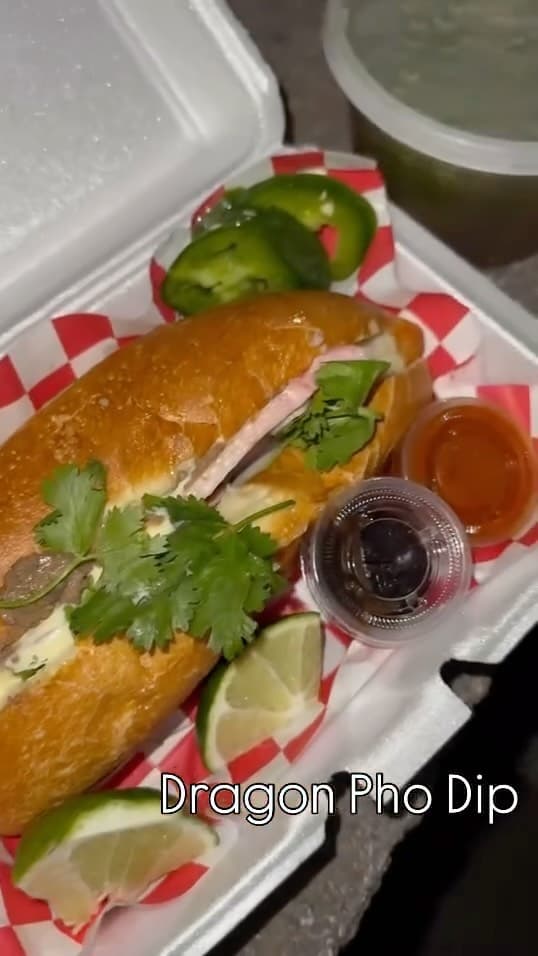 Bánh mì served in a paper tray with dipping sauce